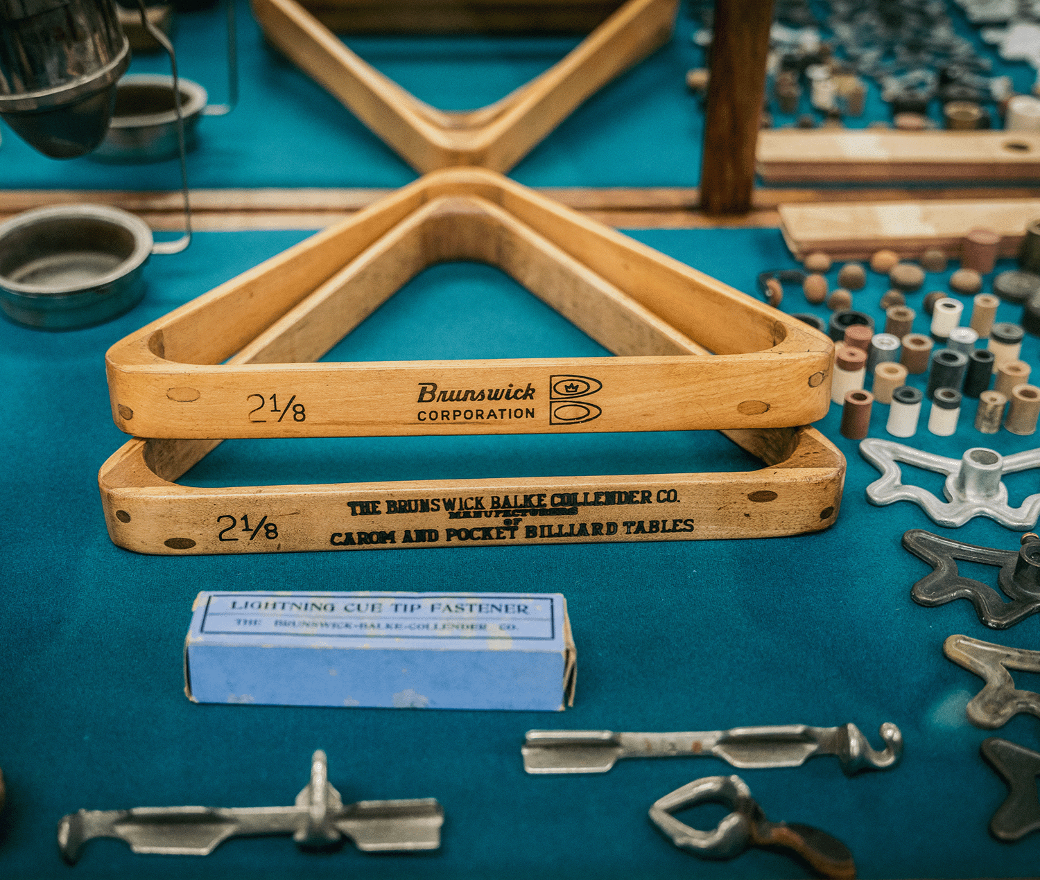 Antique Brunswick billiard rack triangles, cue tip fastener, cue ferrules, and cue tips in a mirrored case